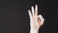 Ok hand sign and wear latex glove on black background Royalty Free Stock Photo