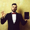 OK sign and black tablet in hands of bearded businessman