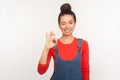 Okay, agree with you! Portrait of cheerful stylish pretty girl with hair bun in denim overalls showing ok hand sign
