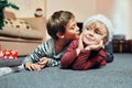 Okay, just because its Christmas you can kiss me. an adorable little boy giving his brother a kiss while waiting to open Royalty Free Stock Photo