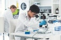 Okay lets adjust that a little closer...an attractive young female scientist looking through a microscope in a Royalty Free Stock Photo