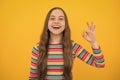 Okay. Portrait of teen girl making ok gesture, isolated background. Young teenager smiling and giving okey sign. Happy Royalty Free Stock Photo