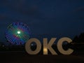 OKC Sign at Night with the Fully Lit Wheeler Ferris Wheel in the Background in Oklahoma City Royalty Free Stock Photo