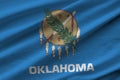 Oklahoma US state flag with big folds waving close up under the studio light indoors. The official symbols and colors in