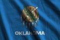 Oklahoma US state flag with big folds waving close up under the studio light indoors. The official symbols and colors in