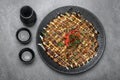 Okonomiyaki traditional japanese savoury pancake dish in restaurant on grey background Royalty Free Stock Photo