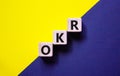 OKR, objectives and key results symbol. Concept words OKR objectives and key results on wooden cubes on a beautiful blue