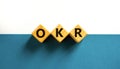 OKR, objectives and key results symbol. Concept words OKR objectives and key results on wooden cubes on a beautiful white