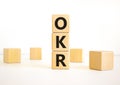 OKR, objectives and key results symbol. Concept words OKR objectives and key results on wooden cubes on a beautiful white