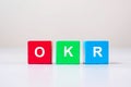 OKR text Objectives, Key and Results wooden cube blocks on table background. business target and focus concepts