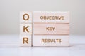 OKR text Objectives, Key and Results wooden cube blocks on table background. business target and focus concepts