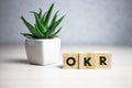 OKR word written on wood block. abbreviation of Objective Key Results text on wooden table for your desing, concept