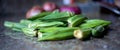 Okra with onions in the background.