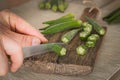 Okra cut with a knife on a chopping board in the kitchen