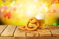 Oktoberfest concept with beer and pretzel on wooden table over autumn background Royalty Free Stock Photo