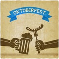 Oktoberfest concept. Hand with beer mug and sausage old background