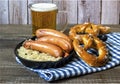 Oktoberfest concept. Traditional german sausages bratwurst with sauerkraut, beer, and pretzels Royalty Free Stock Photo