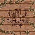 Oktoberfest lettering with wreath leafs in wooden background