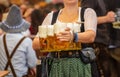 Oktoberfest, Munich, Germany. Waiter with traditional costume holding beers Royalty Free Stock Photo