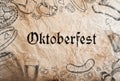 Oktoberfest sign with various hand drawn symbols, paper background.