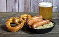 Oktoberfest traditional food. German sausages bratwurst with sauerkraut, beer, and pretzels Royalty Free Stock Photo