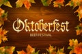 Oktoberfest vintage frame with beer and autumn leafs on the wood background .