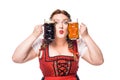 oktoberfest waitress in traditional bavarian dress holding mugs with light and dark beer Royalty Free Stock Photo