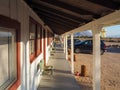 Olancha, USA - 06.06.2016: Wooden porch of motel in California desert with cars parked in front. Accomodation under blue