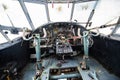 An old, abandoned airplane cockpit with handlebars and cranks