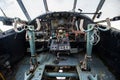 An old, abandoned airplane cockpit with handlebars and cranks