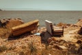 An old abandoned armchair and sofa bed by the sea, garbage on the nature. nature pollution. Royalty Free Stock Photo