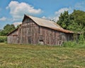 An old abandoned barn in the country with a blue sky and white clouds