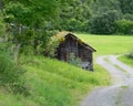 Old abandoned barn on the roadside in a green field Royalty Free Stock Photo