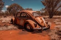 Old abandoned beetle style vehicle on a lonely road in the dusty, red arid land of outback Australia