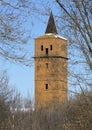 Old, abandoned brick and terracotta tower, structure red, with a
