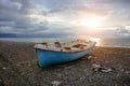 Old abandoned broken fishing boat on sea shore at sunset Royalty Free Stock Photo