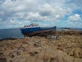 Old abandoned broken ship on the stoned coast sea side. cloudy sky storm time Royalty Free Stock Photo