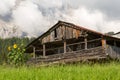 Old abandoned cabin in front of cloud covered mountains