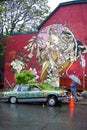 Old abandoned car with growing plants on it in Kensington Market with mural background Royalty Free Stock Photo