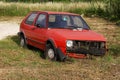 An old abandoned car rusts by the road