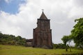 Old abandoned church in green field. Medieval ruin in summer landscape. Christian temple from brown stone. Royalty Free Stock Photo