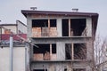 An old abandoned concrete unfinished house, with wooden props at Windows. Construction of private houses. Building demolished