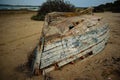 Old abandoned damaged fishing boat turned upside down at the beach