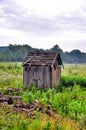 Old abandoned destroyed a barn in a green field Royalty Free Stock Photo