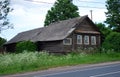 An old abandoned dilapidated village house near the road on a Sunny summer day. Russian provinces.