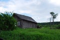 An old abandoned dilapidated village house near the road on a Sunny summer day. Russian provinces.