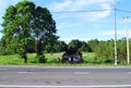 An old abandoned dilapidated village house near the road on a Sunny summer day. Russian provinces.