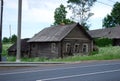 An old abandoned dilapidated village house near the road on a Sunny summer day. Russian provinces.