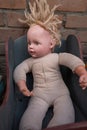 Old abandoned dirty doll with matted hair in a wooden stroller