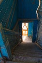 Old abandoned dirty wooden staircase in empty building with blue wooden walls Royalty Free Stock Photo